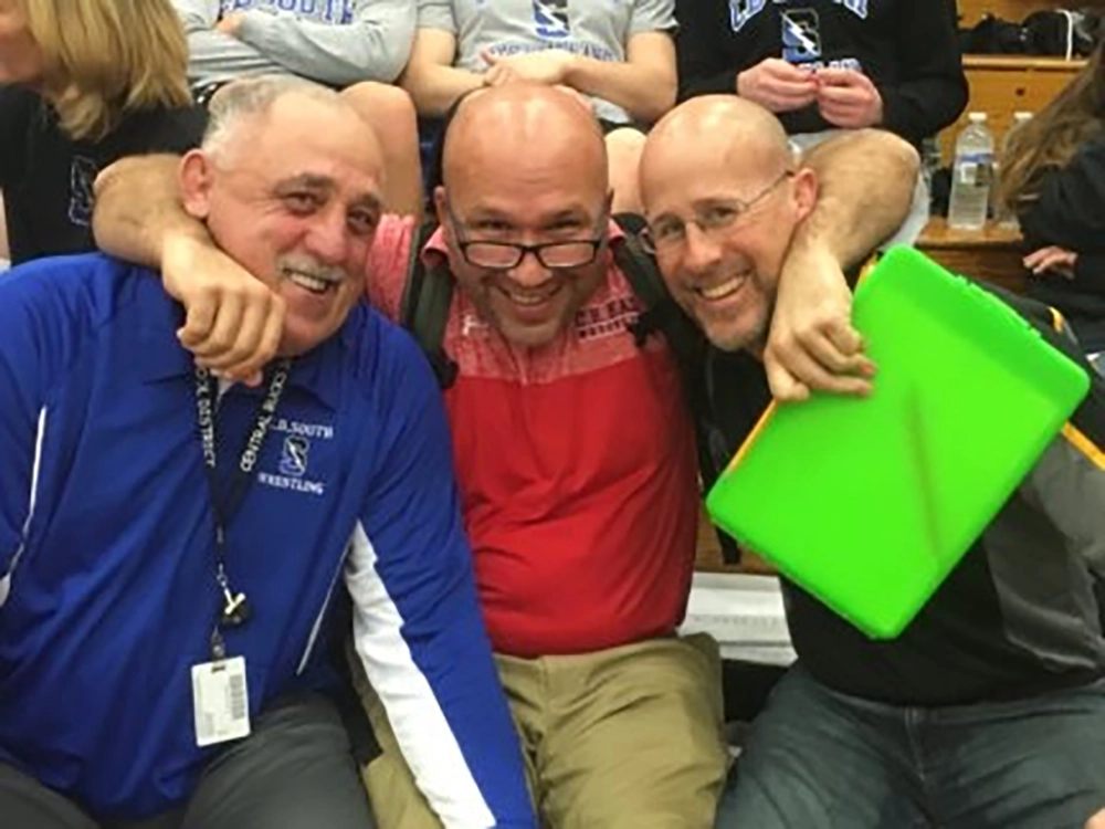 Joe Rigous on sidelines with fellow wrestling coaches
